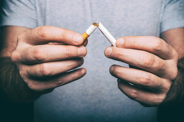 Quitting smoking - male hand crushing cigarette - Photo, Image