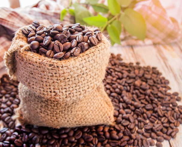 Roasted coffee beans in burlap sack  - Фото, зображення