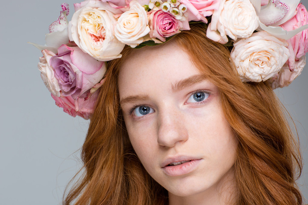 Charming female with red hair in wreath of flowers - Fotó, kép