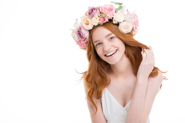 Cheerful happy young redhead woman in roses wreath  - Фото, изображение