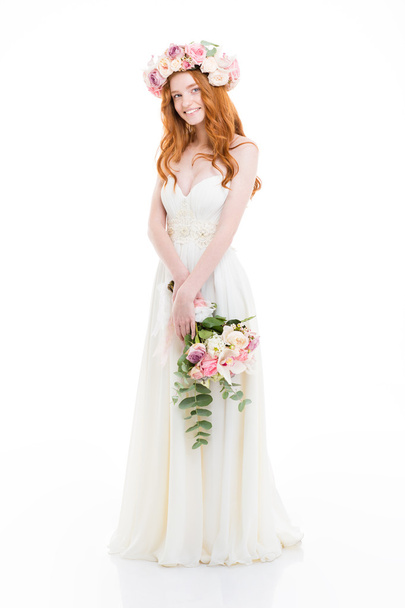 Smiling redhead woman in dress holding flowers - 写真・画像