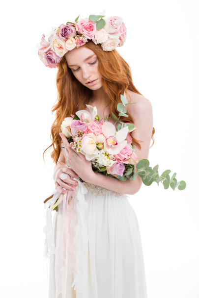 Beautiful redhead woman in dress holding flowers - Foto, afbeelding