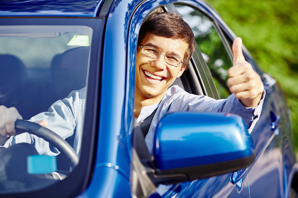 Guy inside car showing thumbs up - 写真・画像