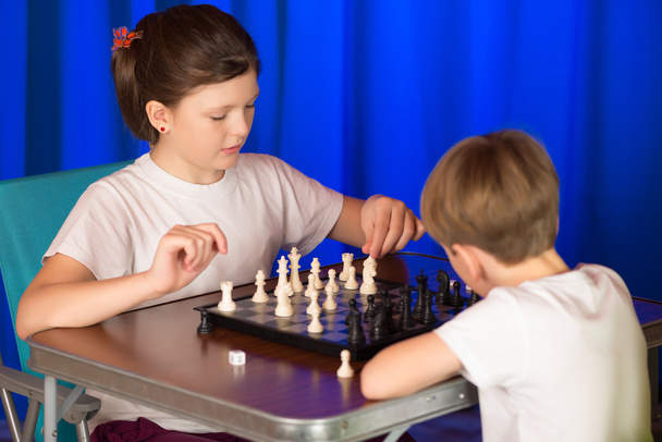 Lapset pelaavat lautapeliä nimeltä shakki.
. - Valokuva, kuva