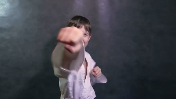 хлопчик-підліток в кімоно карате битися руками махаючи кулаками повільний рух
 - Кадри, відео