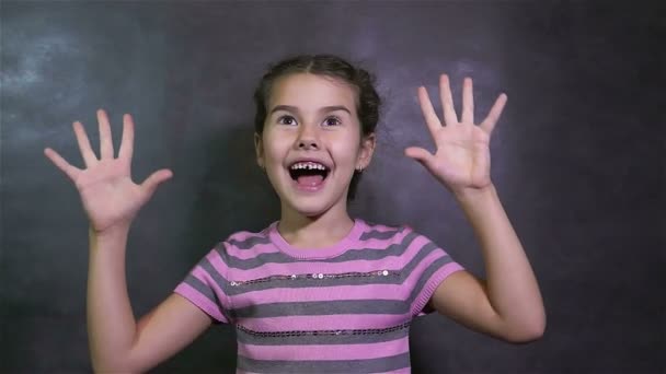 дівчина-підліток відчуває радість від несподіваного щастя на сірому фоні сюрприз
 - Кадри, відео