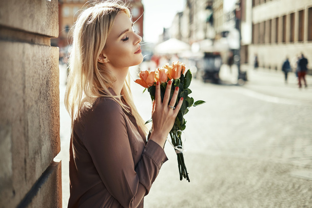 Pretty lady smelling fragrant roses - Fotó, kép