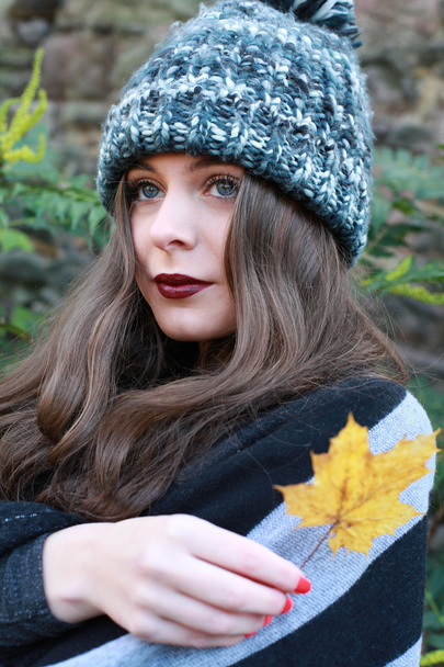 Krásná dospívající dívka na podzim držící list - Fotografie, Obrázek