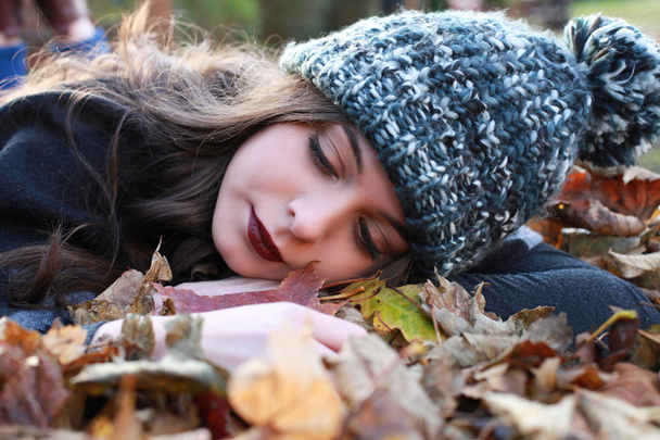 Красивая девочка-подросток лежит на кровати из опавших листьев
 - Фото, изображение