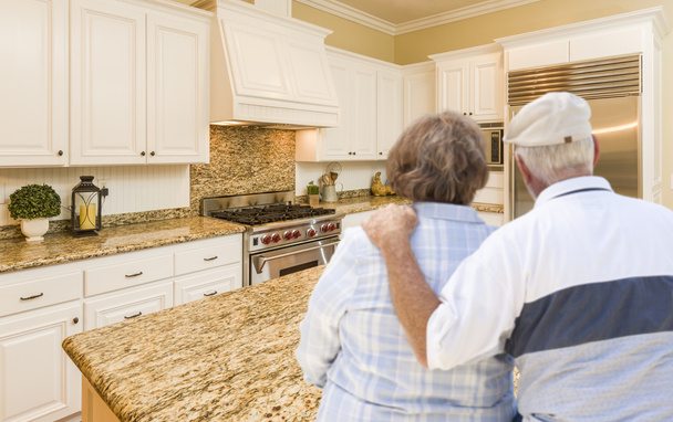 Seniorenpaar schaut über schöne eigene Küche - Foto, Bild
