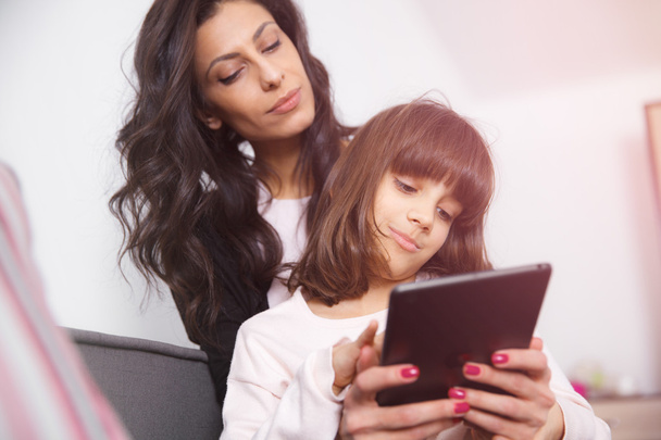 Мать и дочь смотрят на цифровой планшет
 - Фото, изображение