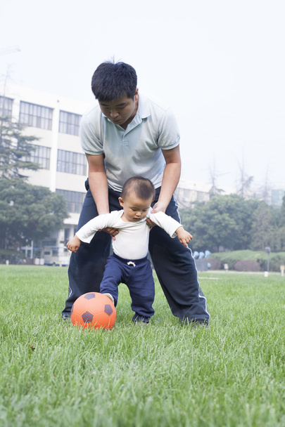 Kínai Atya és fiú játék futball-rét - Fotó, kép