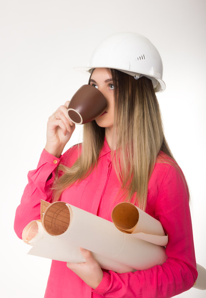 beautiful woman civil engineer holding blueprints. young female architect drinking coffee from a brown cup - Foto, Bild
