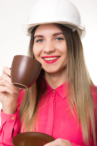 beautiful woman civil engineer holding blueprints. young female architect drinking coffee from a brown cup - Фото, зображення