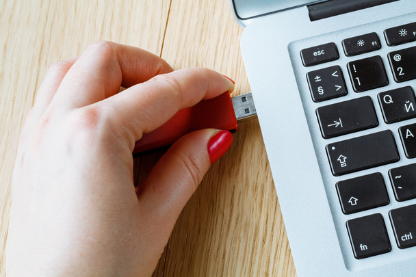 Close up of a woman hand plugging a pendrive on a laptop - Foto, Bild