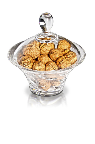 Nutmegs in glass jar on white background - Photo, Image