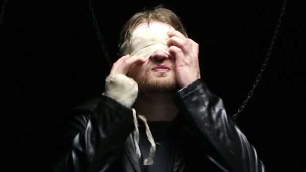 Blinder blonder Mann zieht Mullbinde aus - Filmmaterial, Video