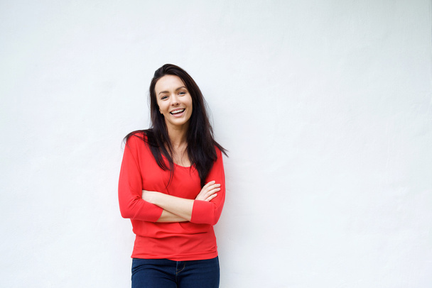 Smiling young woman in red shirt smiling against white background - Foto, afbeelding