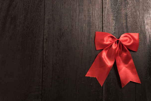 Red bow on old wood - Foto, imagen