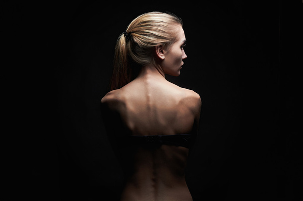 young woman with naked back over black background.sport body girl - Foto, imagen