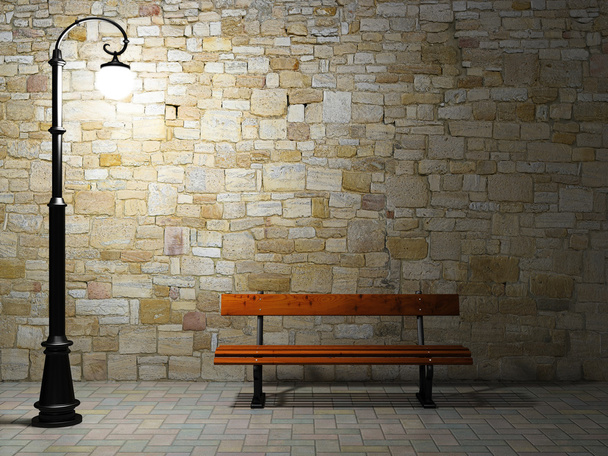 Illuminated brick wall with old street light and bench - Photo, Image