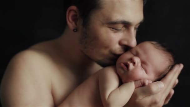 Liefdevolle jonge vader teder houden in zijn handen schattig slapende pasgeboren baby zoon zoenen hem - Video