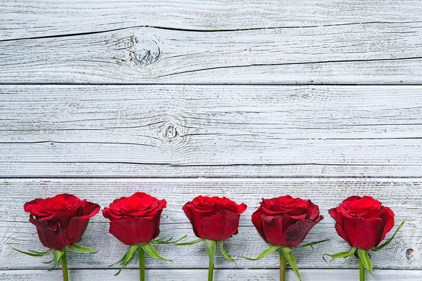 Red roses on wooden board - 写真・画像