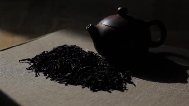 MINSK, BELARUS - NOVEMBER 24, 2014: Small stylish brown tea pot and aromatic premium oolong tea Da Hong Pao tea leaves pile lying in front of it - close up tracking shot - Footage, Video