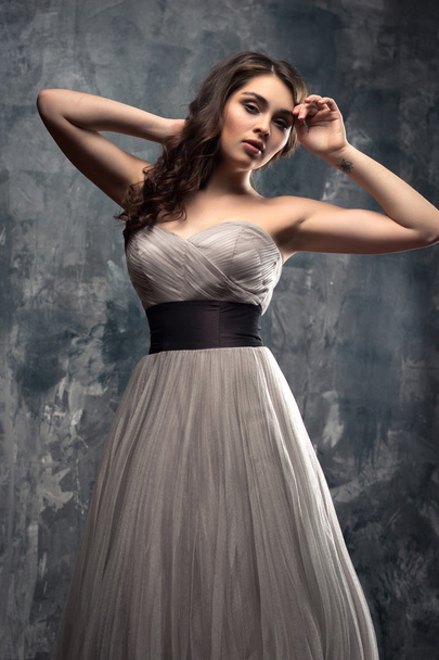 Fashion beauty portrait of gorgeous young woman with long curly hair in luxury evening dress - Photo, image