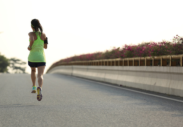 nainen juoksija käynnissä tiellä
 - Valokuva, kuva