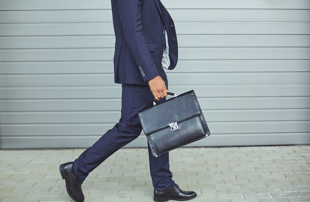 Legs of businessman with briefcase - Foto, afbeelding