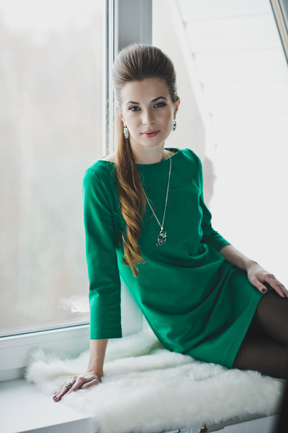 The girl in the green dress on the windowsill 4902. - Valokuva, kuva