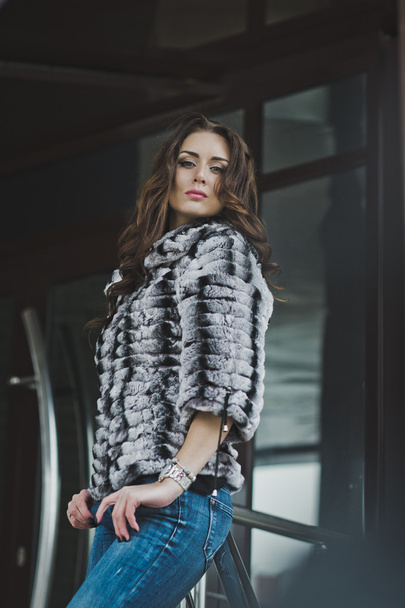 Girl in a fur coat and jeans in the winter on the street 4997. - Foto, immagini