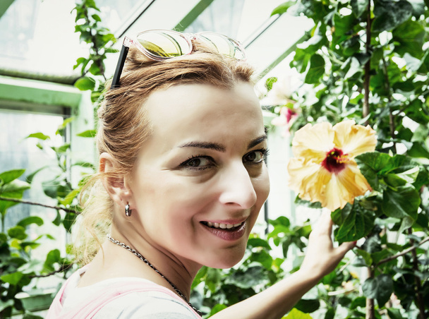 Jeune femme caucasienne admire les fleurs tropicales dans greenhous
 - Photo, image