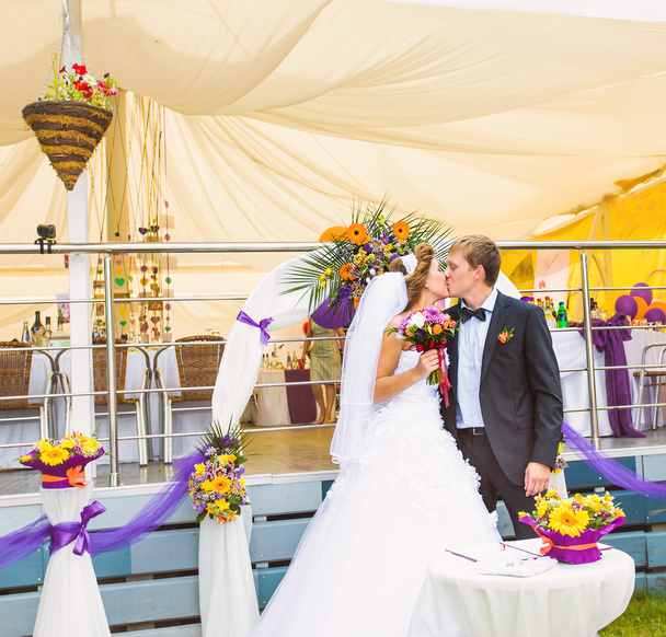 noiva e noivo beijando em sua cerimônia de casamento
 - Foto, Imagem
