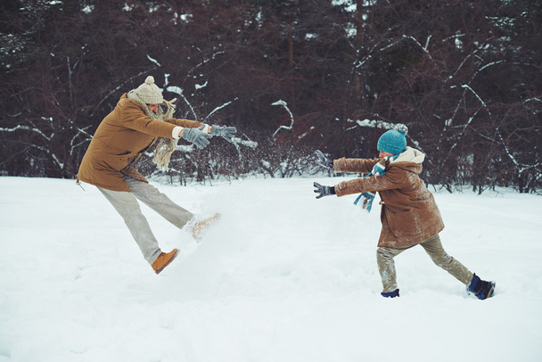 adam ve oğlu rüzgârla oluşan kar yığını içinde oynarken - Fotoğraf, Görsel