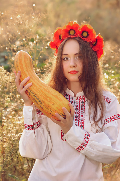 Girl in the Ukrainian national native costume with zucchini - Photo, Image