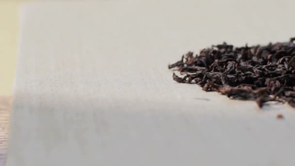 Close up tracking shot of aromatic premium oolong tea Da Hong Pao tea leaves pile on light textured background - Metraje, vídeo