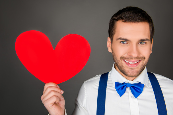 Close up photo pf handsome man with red paper heart - Фото, изображение