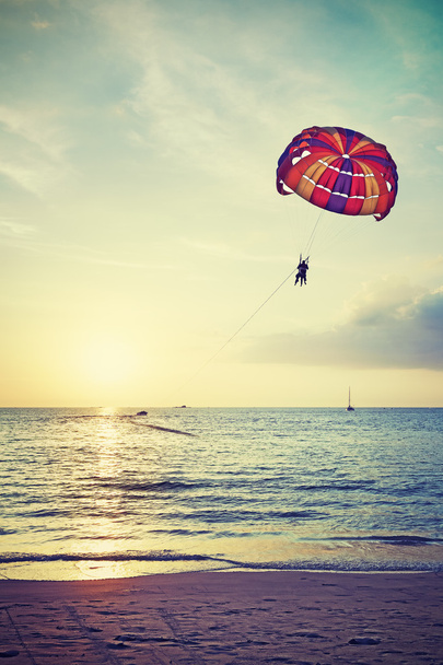 Retro gestileerde paragliders op zonsondergang, zomer avontuur concept. - Foto, afbeelding