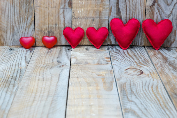 varios corazones rojos sobre un fondo de madera para el Día de San Valentín
 - Foto, imagen