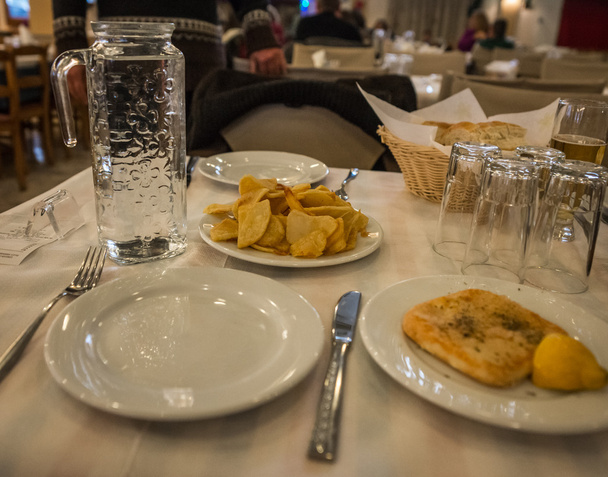 Queso griego a la parrilla con limón y plato de papas fritas
 - Foto, imagen