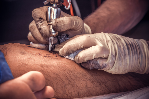 Mostrando il processo di realizzazione di un tatuaggio da artista professionista
 - Foto, immagini