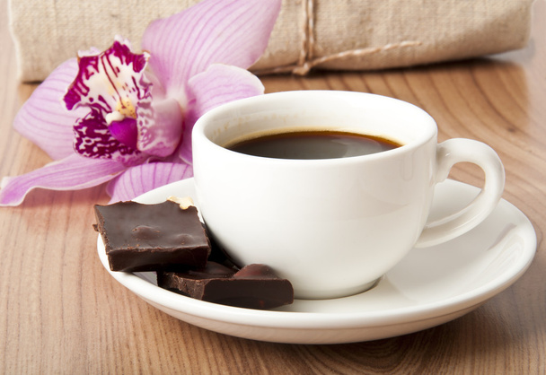 šálek kávy, čokolády a orchidej na dřevěné pozadí - Fotografie, Obrázek