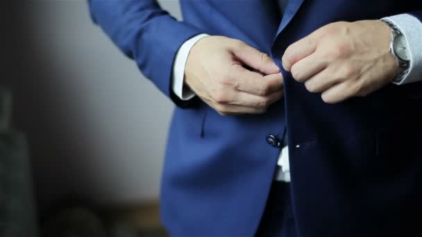 Abbottonare una giacca. Uomo elegante in un abito bottoni di fissaggio sulla giacca che si prepara ad uscire. Da vicino. - Filmati, video