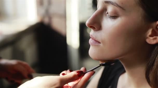 Professionele make-up artiest toepassing Stichting onder ogen zien van model met behulp van een penseel. Close-up - Video