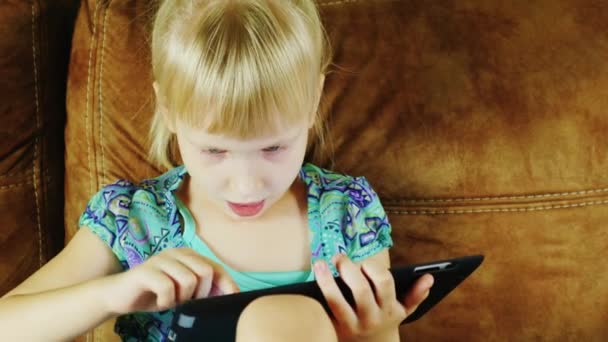 Blonde girl plays on the tablet - Кадри, відео