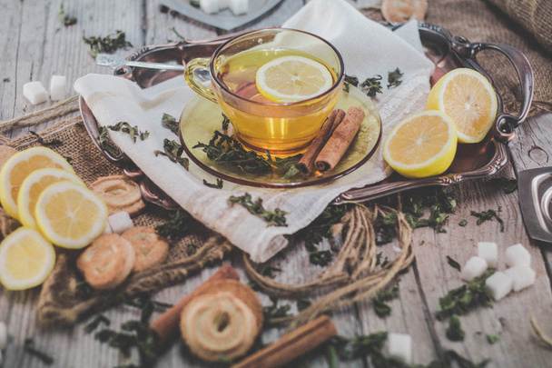 Sušený mátový čaj s citronem a soubory cookie na dřevěný stůl - Fotografie, Obrázek