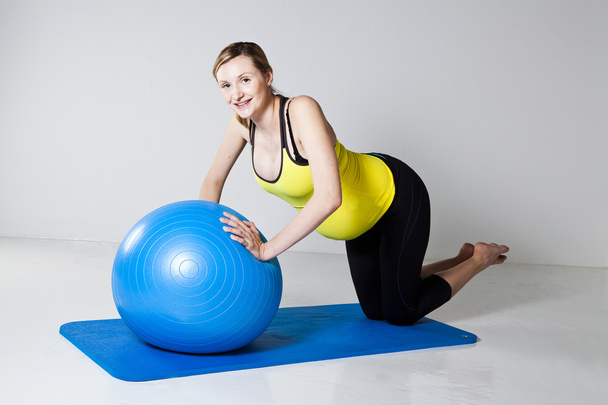 Pregnant woman doing push-up exercise - Фото, изображение