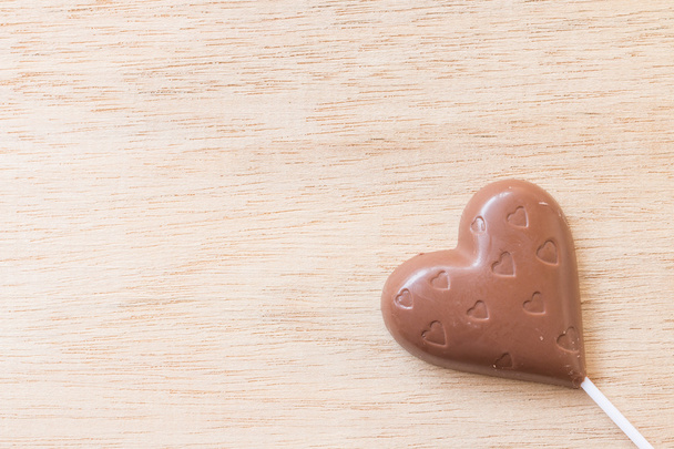 Chocolate hearts candies on wooden background - Fotó, kép